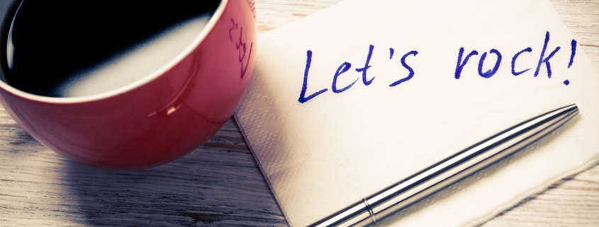 Cup of coffee and napkin with writings on table